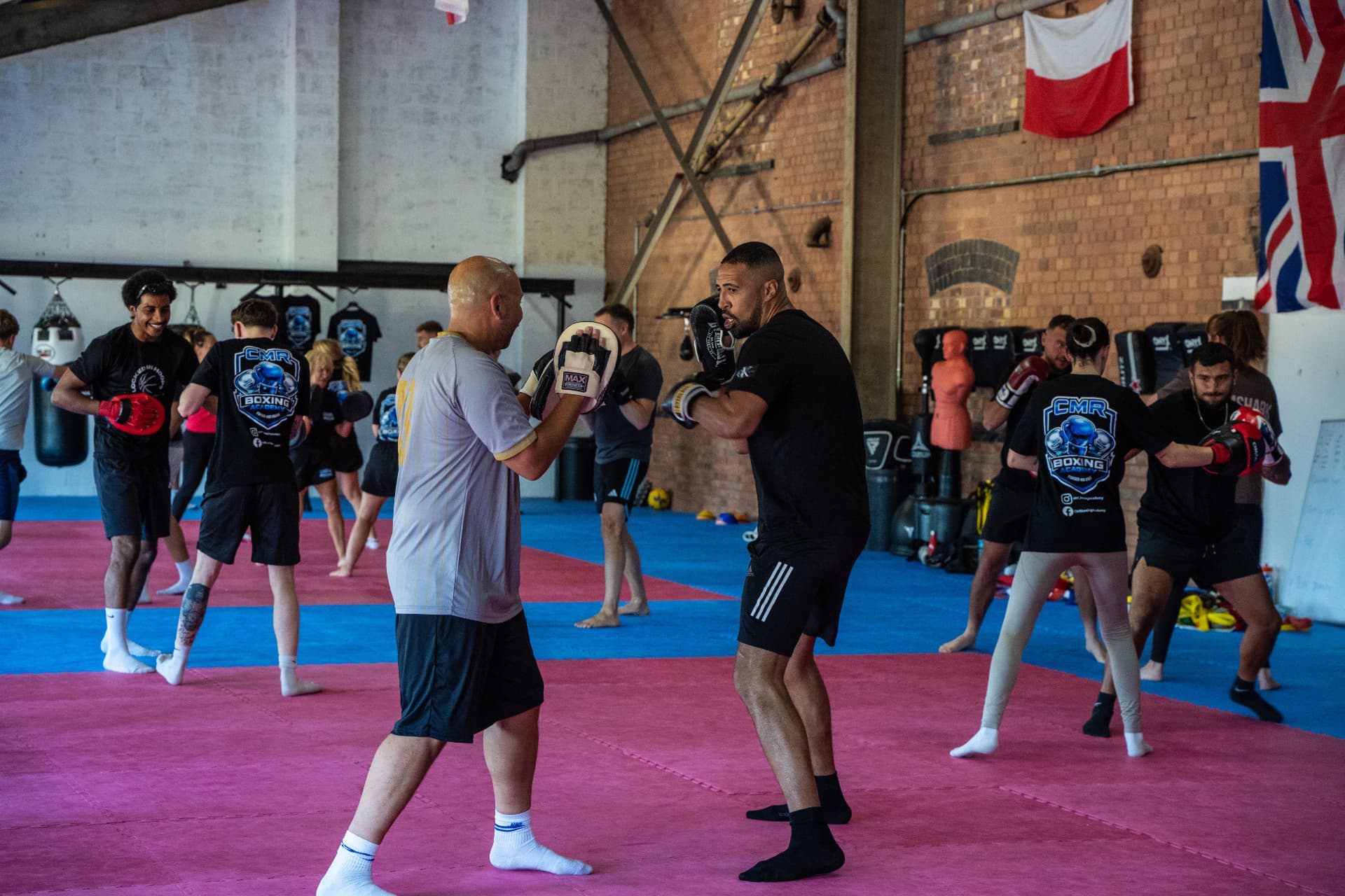 Packed CMR Boxing Academy class doing pad work on the mats