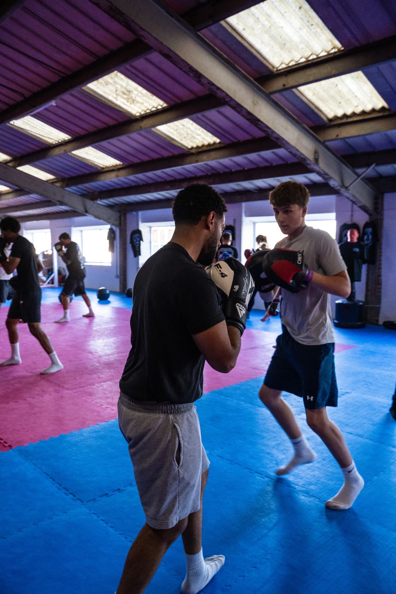 Young boxer holding pads for a partner at CMR